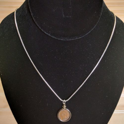 Indian Head Cent coin necklace displayed on black jewelry bust