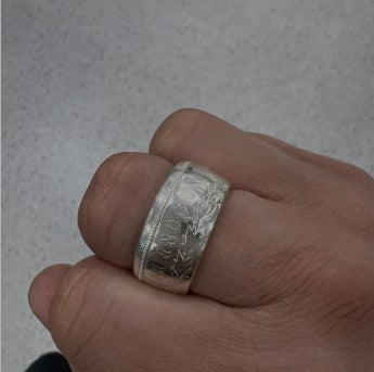 Two-tone handcrafted CoinCrafters coin ring displayed on a dark surface