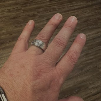 Close-up of a handcrafted silver U.S. coin ring worn by a customer
